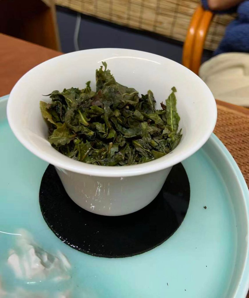 Brewed Anxi Tieguanyin tea leaves showing their green color, softness and natural shape after steeping